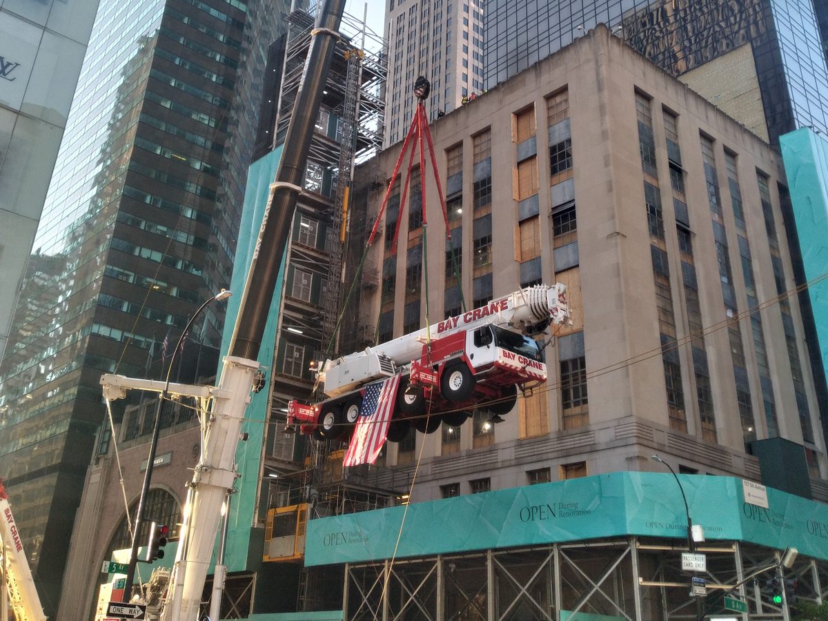 Crane lifting between high-rise buildings