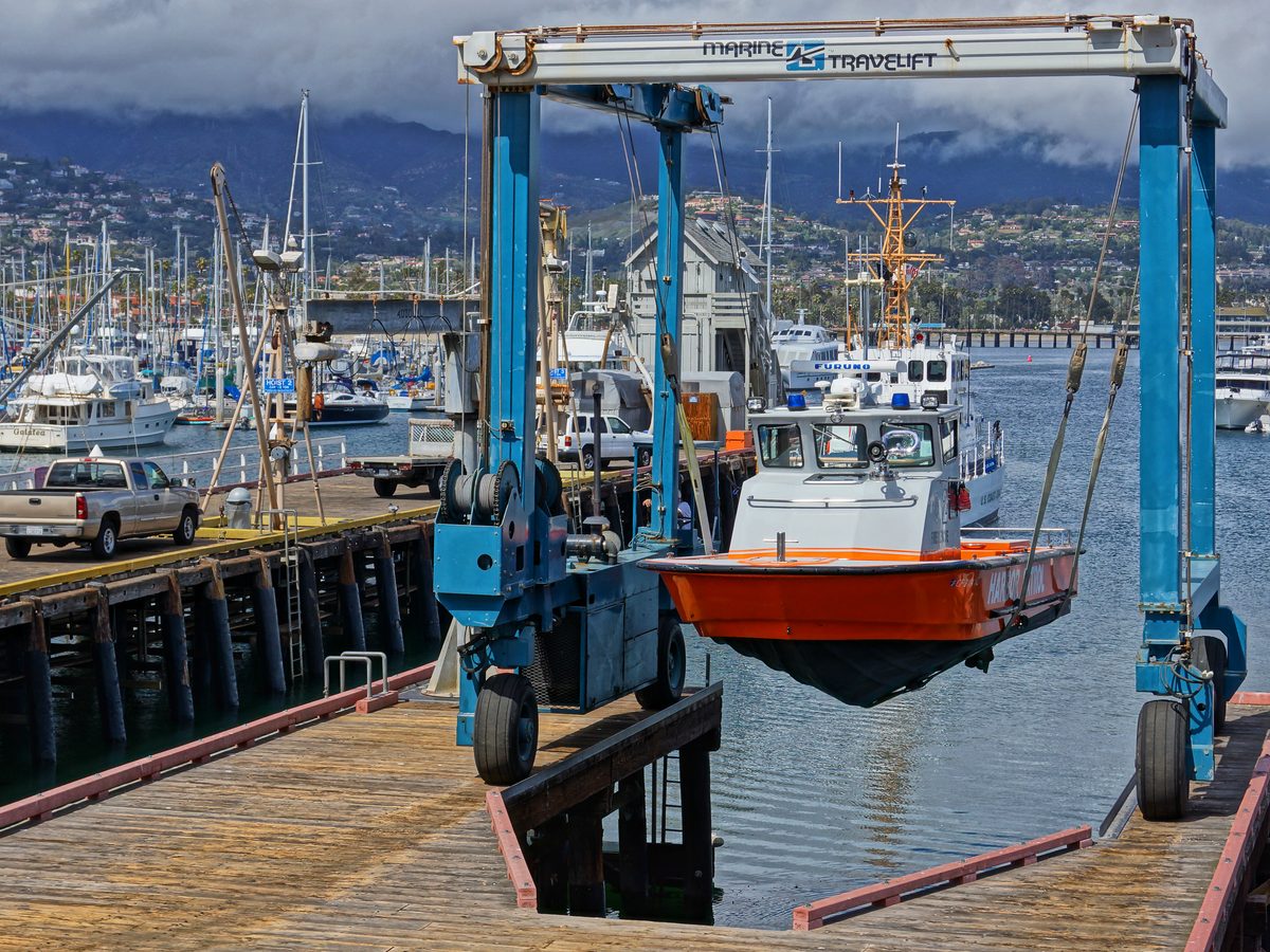 Travel lift lowering a boat into the harbour